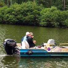 Kyle Moon and a client in the Alabama Aquarium electrofishing boat in a lake.